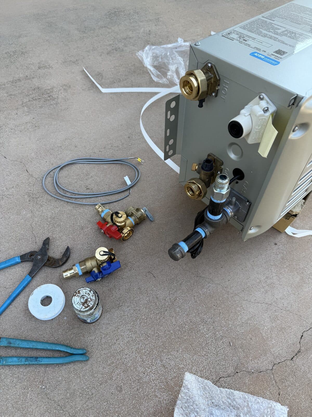 Tankless water heater and its fittings laid out before installation