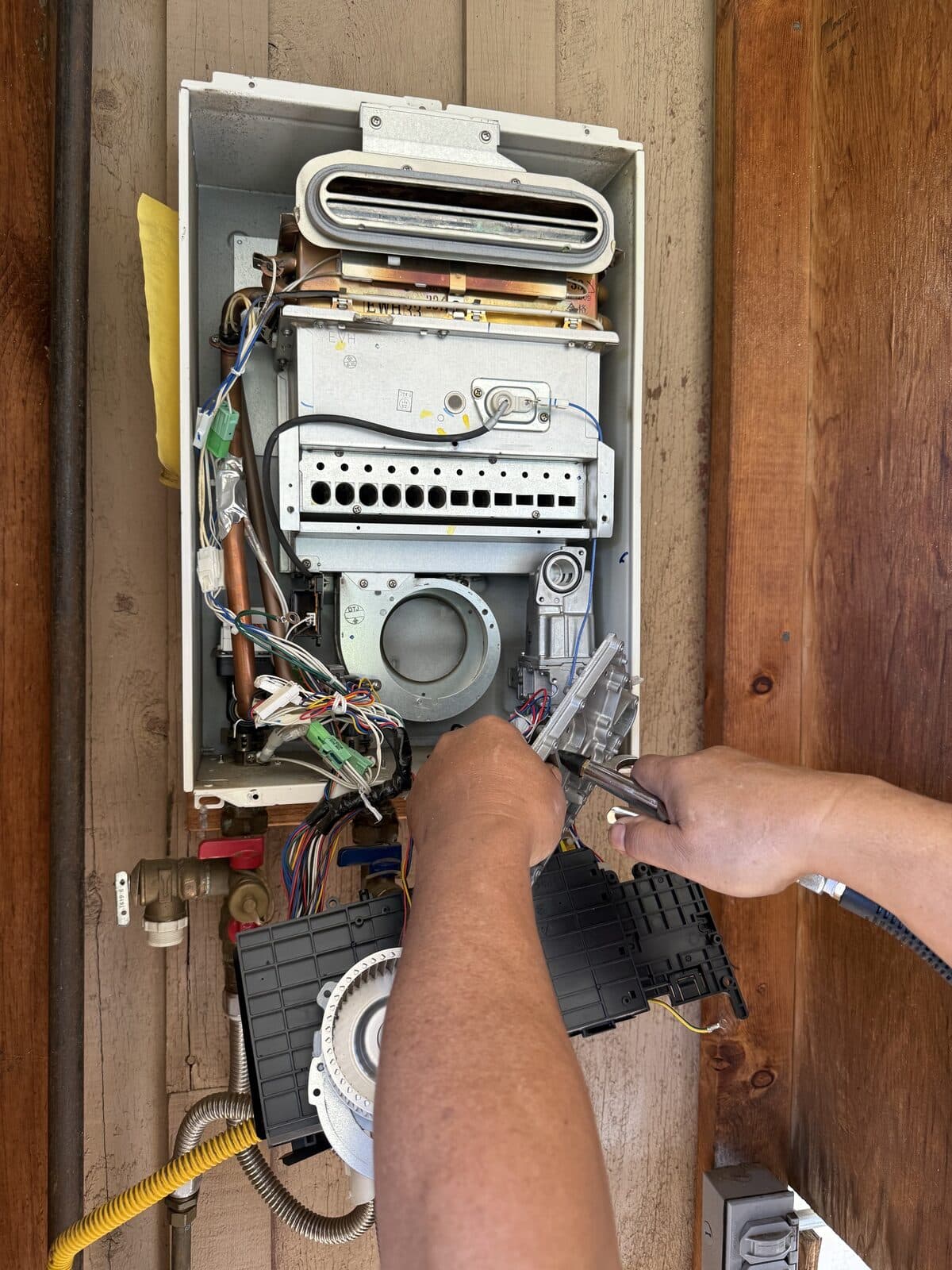 Technician servicing the internal components of a tankless water heater